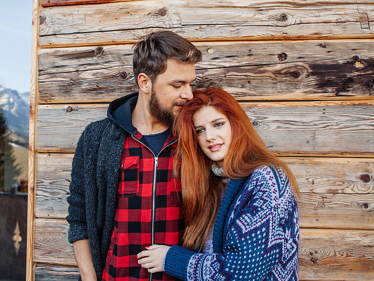 New Year's Day, Warm Clothing, Women, Men, Males, Two People, Comfortable, Celebration, Valentine's Day - Holiday, Cute, Cabin, Adult, Smiling, Laughing, Standing, Playful, Embracing, Fun, Cold - Temperature, Relaxation, Joy, Happiness, Romance, Love, Wood - Material, Nature, Lifestyles, Outdoors, Positive Emotion, Redhead, Married, People, Austria, Winter, European Alps, Mountain Range, Mountain, Porch, Front Stoop, Window, Cottage, Village, Tourist Resort, Christmas, Hot Chocolate, austrian alps, Husband, Bundle Of Wood, New Year